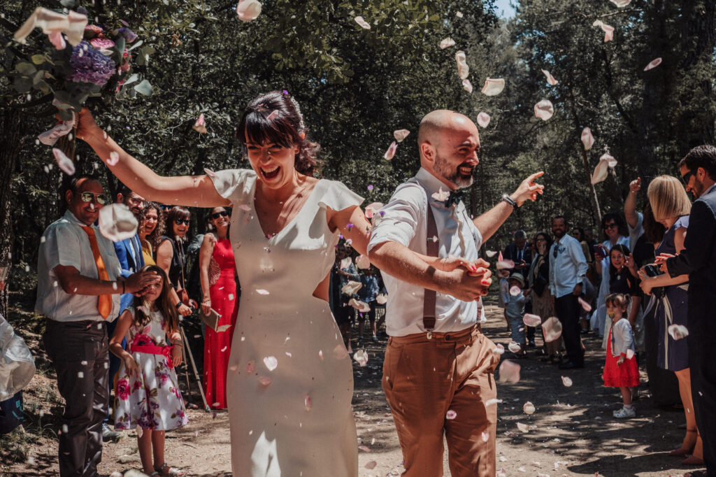 Bride and groom walking through confetti after their El Dalmau wedding ceremony