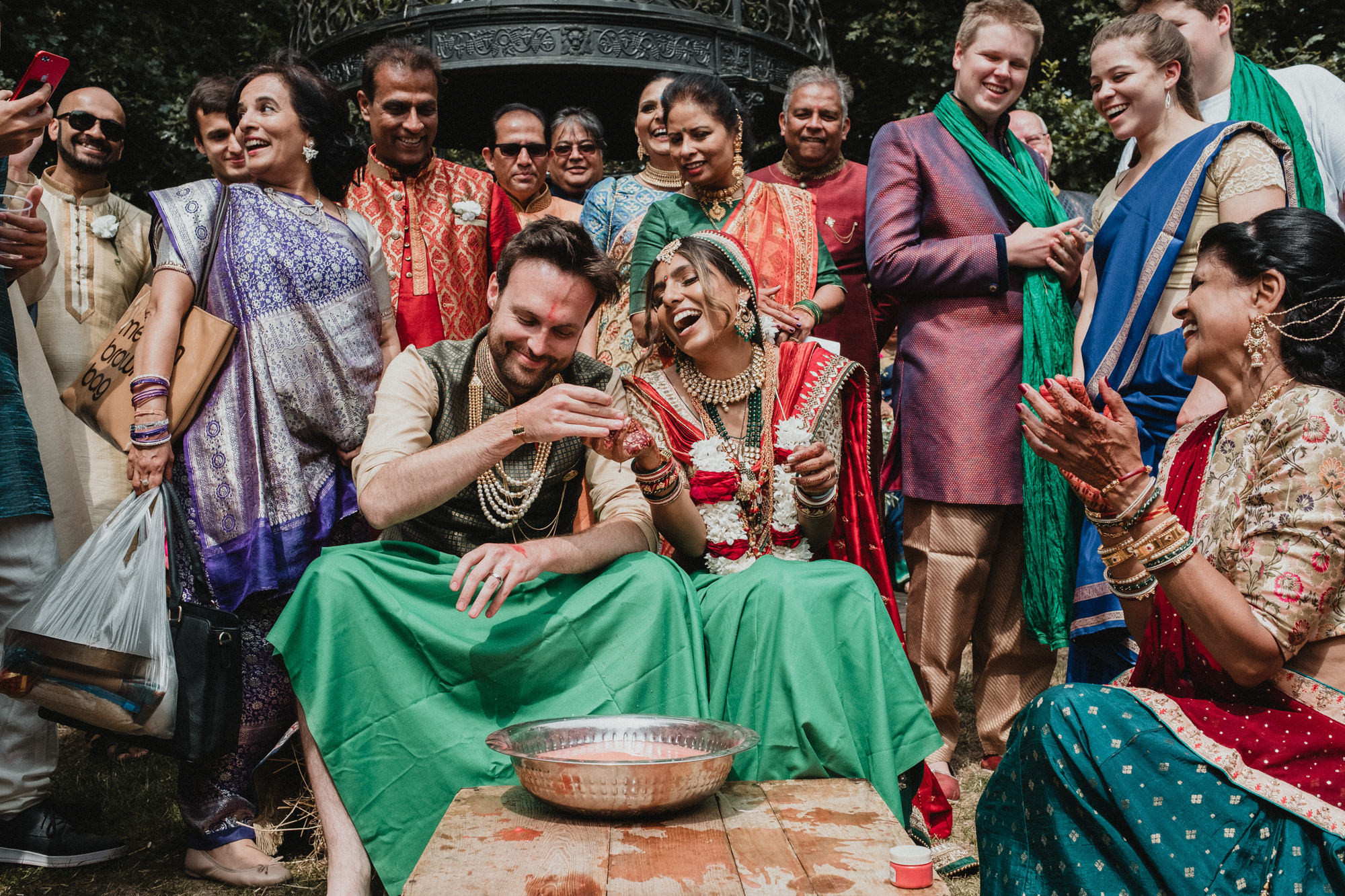 Indian wedding photography in Hampshire with bride and groom surrounded by family during the ceremony
