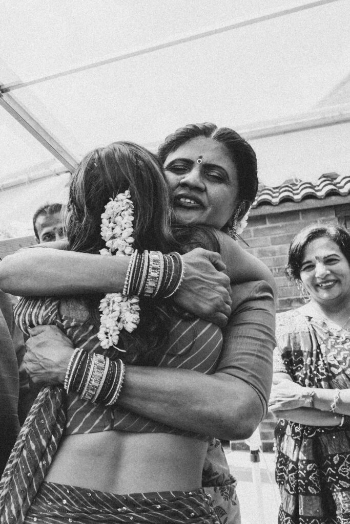 Bride hugging a family member during the Indian wedding celebrations