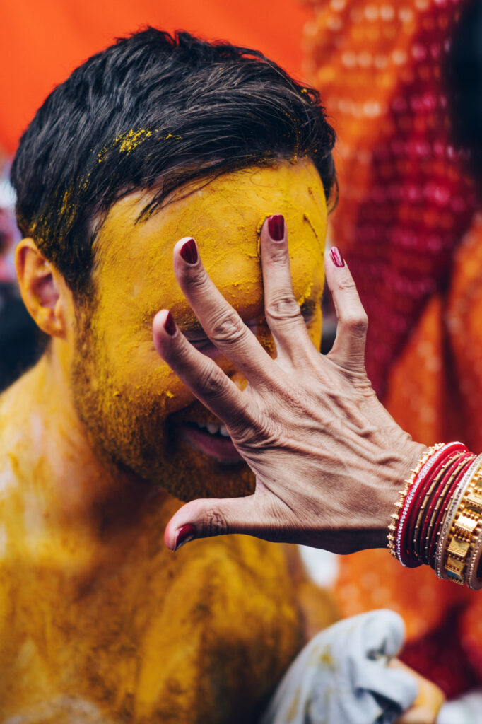 Turmeric-covered hands during the haldi ceremony