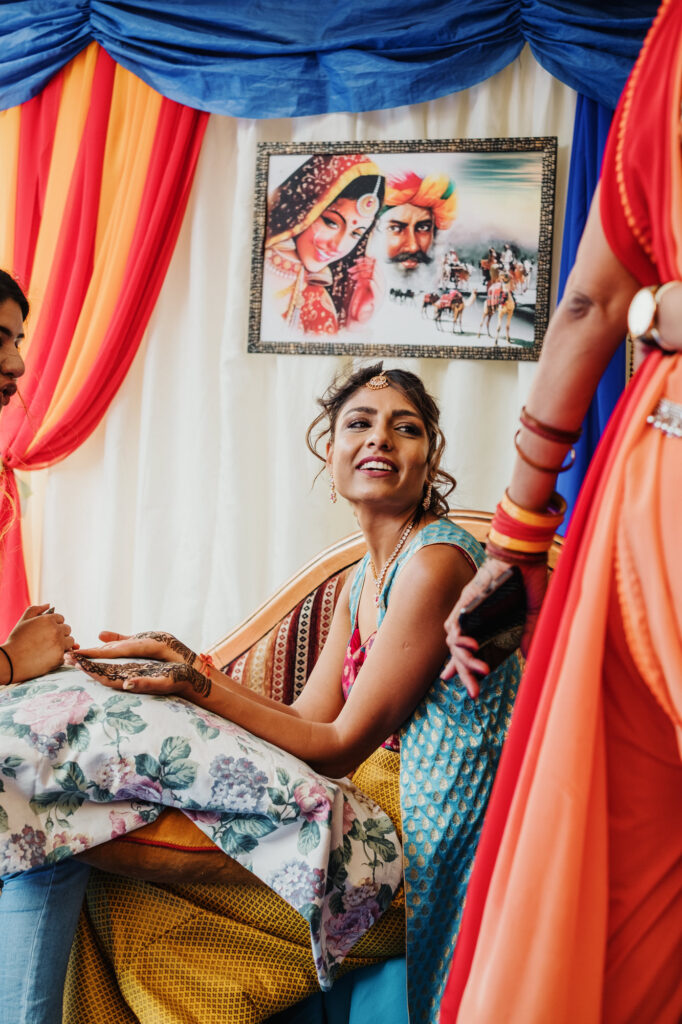 Bride seated during the ceremony with colourful fabric around her