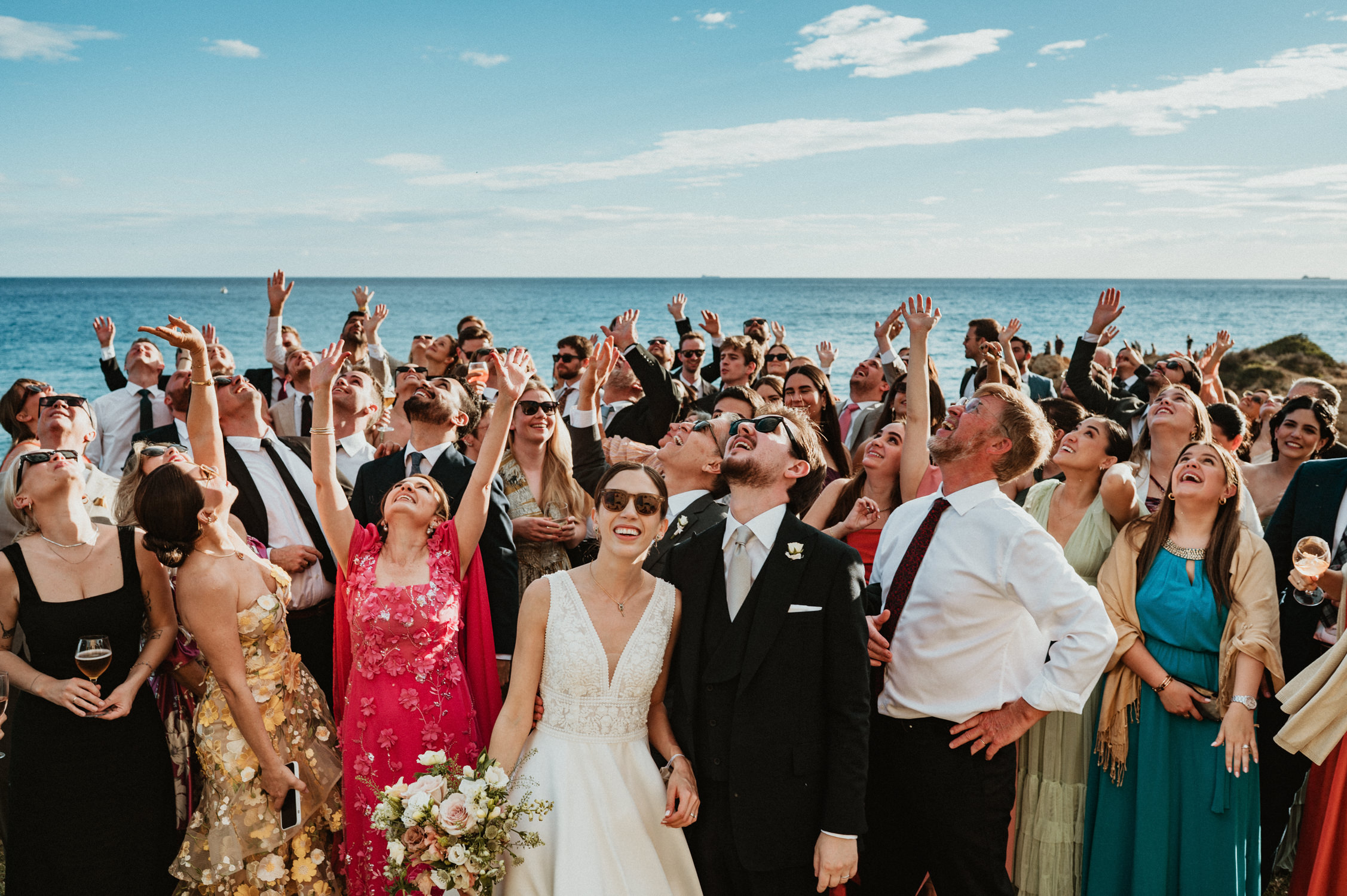 Barcelona wedding photographer capturing guests throwing confetti by the sea