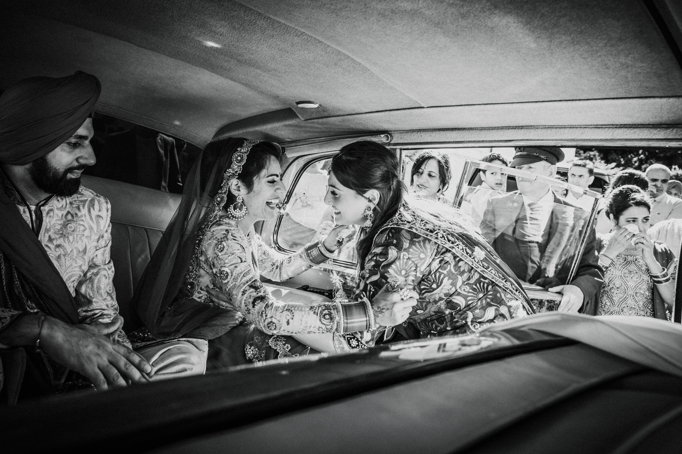 Bride and groom inside a car during an Indian wedding ceremony