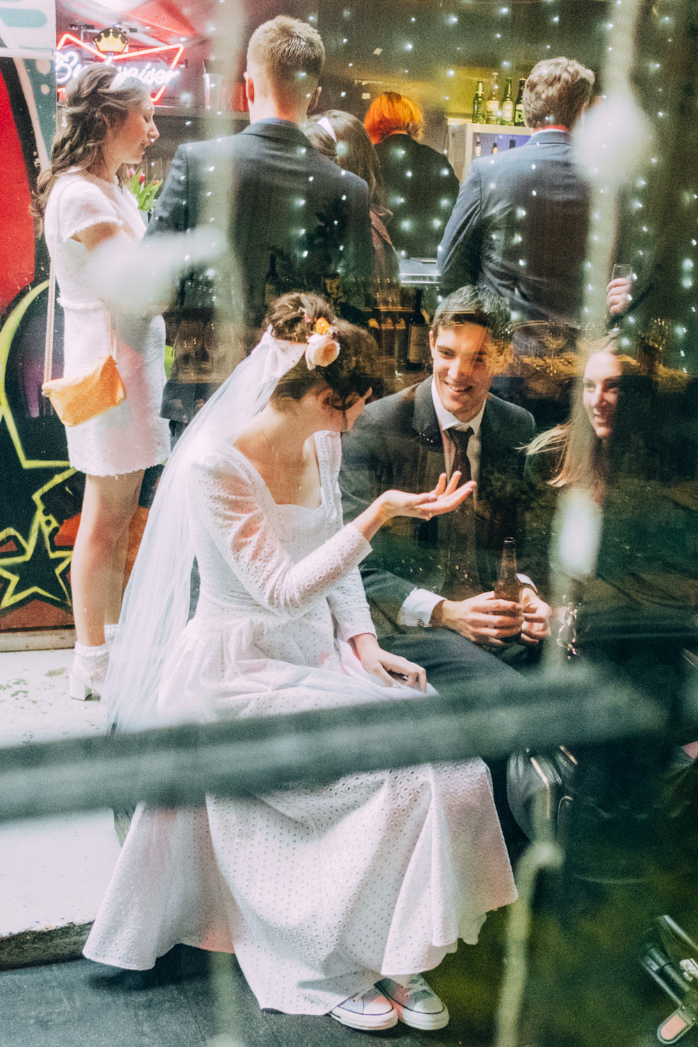 Bride through a window talking with a guest during her wedding reception