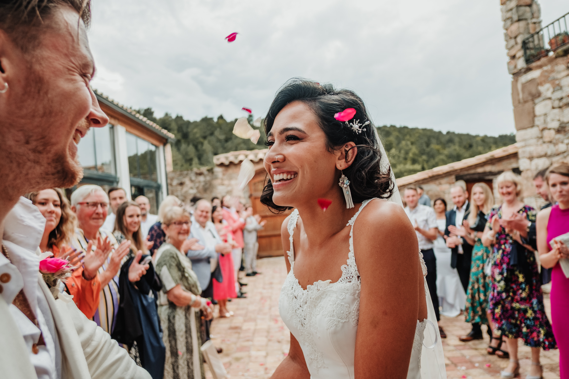 Bride and groom with guests throwing confetti